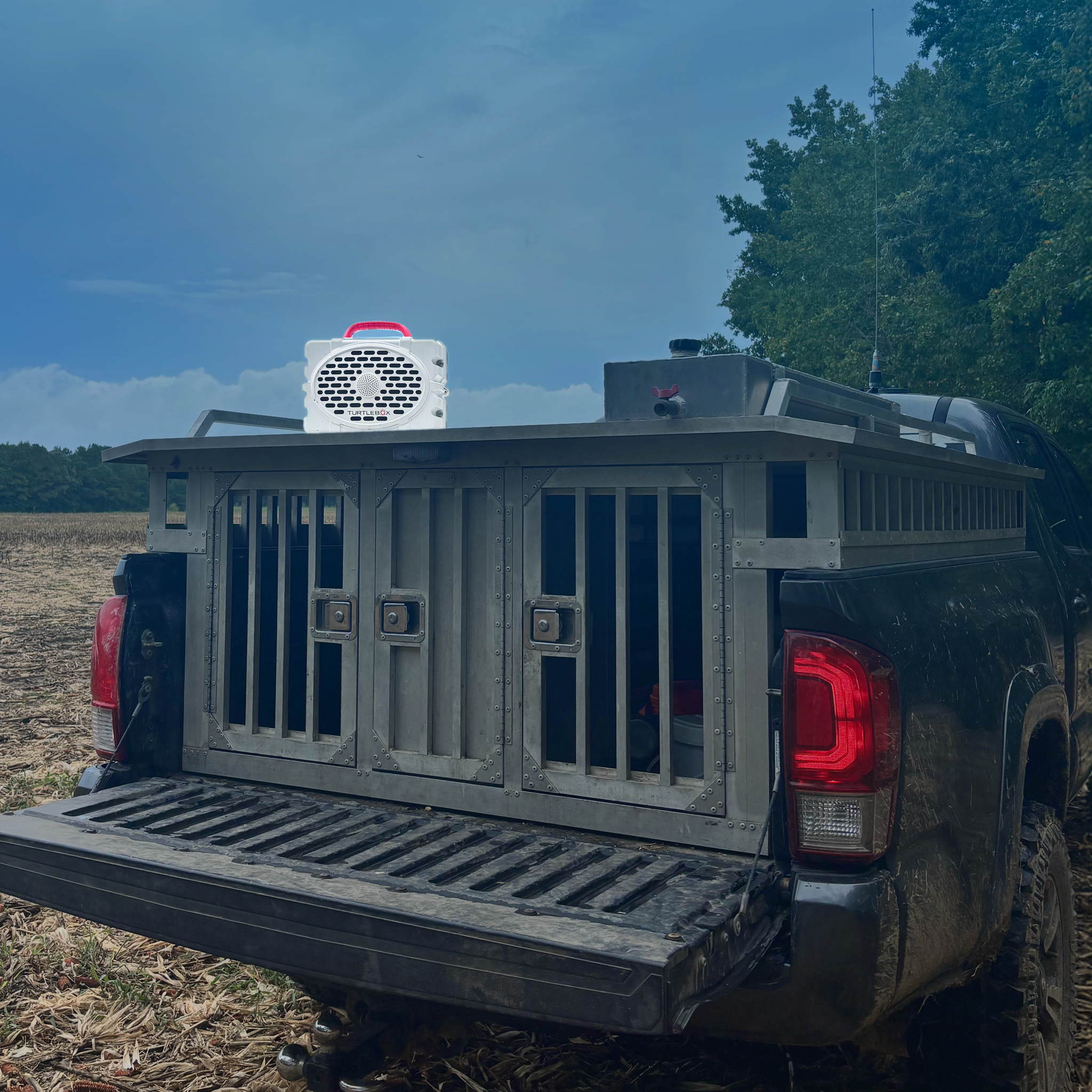 Turtlebox Original Gen 3 Rugged Portable Outdoor Speaker on top of truck with dog box